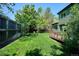 View of the backyard featuring lush grass, a wooden deck, and a privacy fence at 5651 S Himalaya Way, Centennial, CO 80015