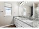 Bathroom features a double sink vanity with granite countertops, large mirror, and modern fixtures at 5651 S Himalaya Way, Centennial, CO 80015
