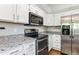 Spacious kitchen with white cabinets, stainless steel appliances, and granite countertops at 5651 S Himalaya Way, Centennial, CO 80015