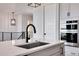 Modern kitchen sink and double oven with sleek black faucet at 14408 Hop Clover Trl, Parker, CO 80134