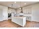 Modern kitchen with white cabinets, island, and stainless steel appliances at 14408 Hop Clover Trl, Parker, CO 80134