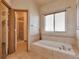Serene bathroom with a soaking tub, tiled surround, and glass-enclosed shower for ultimate relaxation at 14825 Almstead St, Hudson, CO 80642