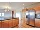 Functional kitchen with island, stainless steel refrigerator and wood cabinets at 14825 Almstead St, Hudson, CO 80642