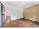 Bedroom with beautiful wood flooring, blue door, and view into the kitchen at 7020 E Girard Ave # 209, Denver, CO 80224