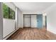 Bright bedroom with wood floors, sliding closet doors, and a view to the exterior at 7020 E Girard Ave # 209, Denver, CO 80224