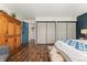 Bright bedroom featuring hardwood floors, wardrobe, blue door, and dual closets at 7020 E Girard Ave # 209, Denver, CO 80224