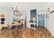 Charming dining area featuring modern lighting, wood floors, and a stylish entrance with a blue door at 7020 E Girard Ave # 209, Denver, CO 80224
