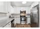 Updated kitchen featuring white cabinets, granite countertops, and stainless steel appliances at 7020 E Girard Ave # 209, Denver, CO 80224