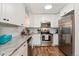 Well-lit kitchen featuring stainless steel appliances, granite countertops, and white cabinets at 7020 E Girard Ave # 209, Denver, CO 80224