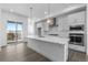 Modern kitchen with a large island, quartz countertops, stainless steel appliances, and abundant natural light from sliding doors at 14261 Currant St, Broomfield, CO 80020