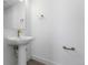 Contemporary powder room featuring a sleek pedestal sink, minimalist mirror, and modern fixtures for an elegant touch at 14261 Currant St, Broomfield, CO 80020