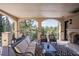 Charming covered patio with stone columns, beautiful views, comfortable seating and a cozy fireplace at 26806 Evergreen Springs Rd, Evergreen, CO 80439
