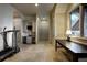 Spacious hallway featuring tile floors, elegant built-ins, and a glimpse of a gym area with a treadmill at 26806 Evergreen Springs Rd, Evergreen, CO 80439
