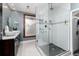 Beautiful bathroom featuring double vanity, a window, and tiled shower with glass doors at 1614 Gaylord St, Denver, CO 80206