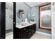 Stylishly designed bathroom with double sinks, large vanity, window, and tiled shower at 1614 Gaylord St, Denver, CO 80206