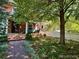 Inviting front yard featuring a brick walkway leading to the home, complemented by mature trees at 1614 Gaylord St, Denver, CO 80206