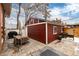 Exterior view of a red garage with a patio and garden, situated in a well-maintained backyard at 1614 Gaylord St, Denver, CO 80206