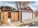 Garage and fenced parking area with a white door, accented by the red brick of the main house at 1614 Gaylord St, Denver, CO 80206