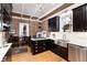 Bright kitchen with stainless steel appliances, dark wood cabinets, and a brick wall at 1614 Gaylord St, Denver, CO 80206