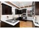 Modern kitchen features stainless steel appliances, dark wood cabinets, and a brick accent wall at 1614 Gaylord St, Denver, CO 80206