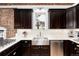 Kitchen area showing stainless dishwasher, white countertops, and dark cabinets at 1614 Gaylord St, Denver, CO 80206