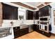 Well-lit kitchen features stainless steel appliances, dark cabinetry and bright white countertops at 1614 Gaylord St, Denver, CO 80206