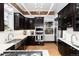 Spacious kitchen featuring stainless appliances, dark cabinets, light countertops, and brick accent wall at 1614 Gaylord St, Denver, CO 80206