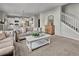 Comfortable living room featuring a stylish sofa, white coffee table, and staircase access at 20727 Park Hollow Dr, Parker, CO 80138