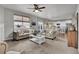 Bright, open living room with tufted sofas, ceiling fan, and seamless flow to kitchen at 20727 Park Hollow Dr, Parker, CO 80138