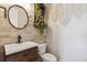 Stylish powder room featuring stone accent wall, modern sink, and decorative plants at 2785 S Lisbon Way, Aurora, CO 80013