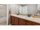 Bathroom featuring dual sinks, wooden cabinets, and a shower/tub combo at 2785 S Lisbon Way, Aurora, CO 80013