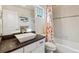 Bathroom featuring a modern sink, dark countertops, and a stylish orange patterned shower curtain at 2785 S Lisbon Way, Aurora, CO 80013