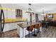 Open kitchen and dining area with a large island, bar stools, and modern appliances at 2785 S Lisbon Way, Aurora, CO 80013