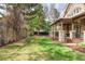 Large backyard with green grass, metal fence, and a covered deck area at 155 S Poplar St, Denver, CO 80230
