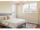A serene bedroom featuring a plush bed, stylish chandelier, and large windows at 155 S Poplar St, Denver, CO 80230