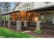 Covered patio with stone columns, wood decking, string lights, and backyard access at 155 S Poplar St, Denver, CO 80230