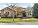 Elegant two-story home featuring stone accents, a symmetrical design, and a beautifully landscaped front yard at 155 S Poplar St, Denver, CO 80230
