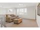 A cozy living room boasts a plush couch, ottoman, and abundant natural light from the large windows at 155 S Poplar St, Denver, CO 80230
