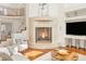 Living room showcasing a rounded fireplace, staircase, and white furniture in an open concept setting at 155 S Poplar St, Denver, CO 80230