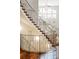 Elegant staircase with decorative iron railings and hardwood floors, leading to a sun-filled living area at 155 S Poplar St, Denver, CO 80230