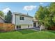The back of the house with a backyard, sliding glass doors, and wooden fence at 5612 S Jebel Way, Centennial, CO 80015