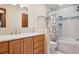 Bathroom featuring a wooden vanity, tiled shower with a glass door, and ample lighting, offering a modern feel at 5612 S Jebel Way, Centennial, CO 80015