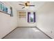 Sunny room featuring plush carpet, shelving, and a ceiling fan, perfect for a cozy bedroom or guest room at 5612 S Jebel Way, Centennial, CO 80015