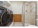 Bright laundry room and bathroom featuring modern appliances, a walk-in shower, and ample storage at 5612 S Jebel Way, Centennial, CO 80015