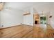 Spacious living room with wood floors, white walls, and ample natural light, seamlessly connected to the kitchen and dining area at 5612 S Jebel Way, Centennial, CO 80015