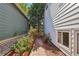 Charming side yard with brick pathway, blooming red roses, and a wooden gate, creating a serene outdoor space at 5612 S Jebel Way, Centennial, CO 80015