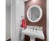 Charming powder room featuring a pedestal sink with modern fixtures and a circular mirror at 14533 W 3Rd Ave, Golden, CO 80401