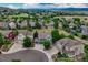 Aerial view of a residential neighborhood nestled amongst green spaces with rolling hills in the distance at 4688 Cedar Glen Pl, Castle Rock, CO 80109