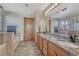 Bright bathroom with dual sinks, granite counters, soaking tub, and wood-look floors at 4688 Cedar Glen Pl, Castle Rock, CO 80109