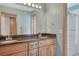 Bathroom with dual sinks, wood cabinets, a large mirror, and a tub with a shower at 4688 Cedar Glen Pl, Castle Rock, CO 80109